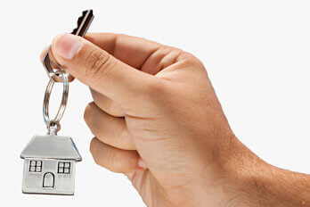 A hand holding a key with silver house pendant for key holding service
